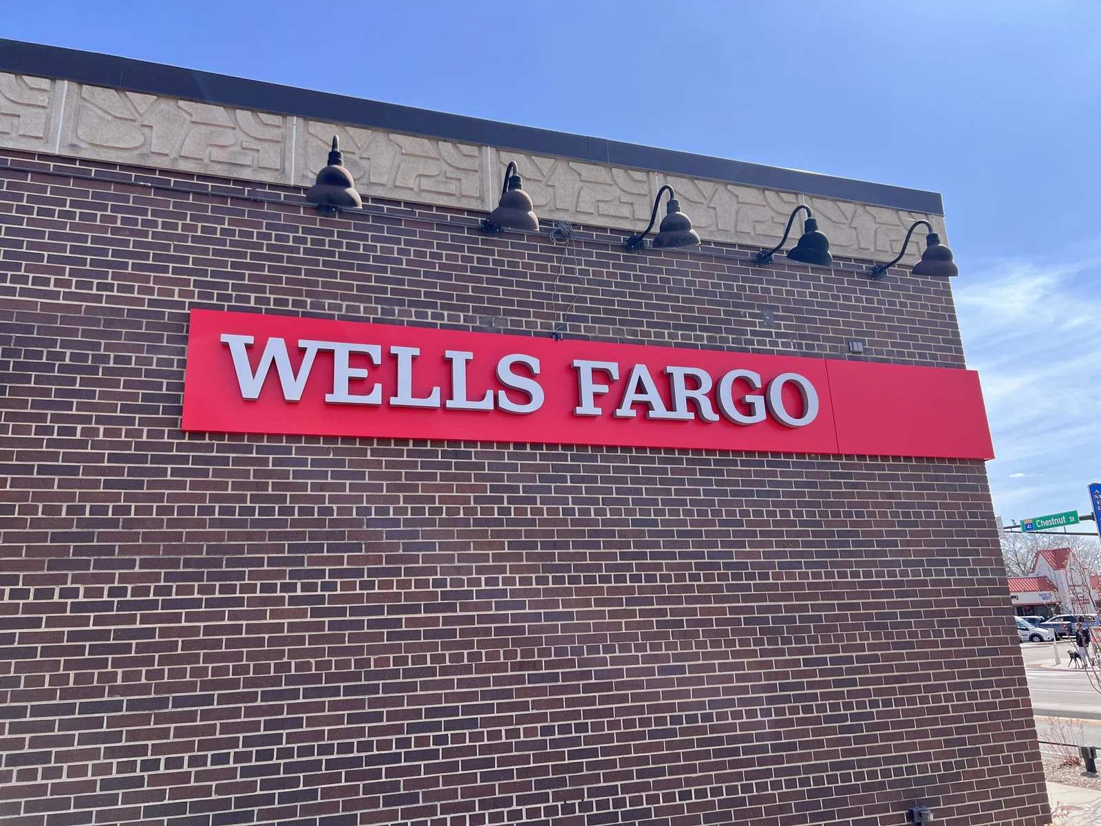 Wells Fargo sign on freshly painted brick exterior with decorative lighting by National Painting Partners