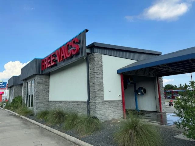 Car wash exterior painting with stone facade and Free Vacs signage by National Painting Partners