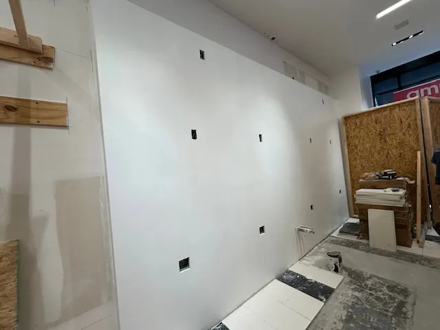 Cosmetics retail store interior drywall after primer and initial painting in Dallas, TX by National Painting Partners