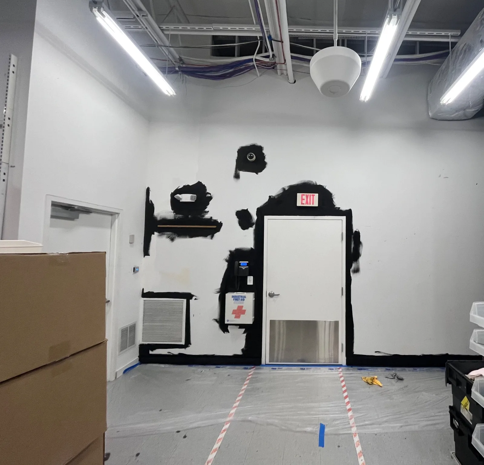 Shielding paint cut in around a stockroom door and exit sign