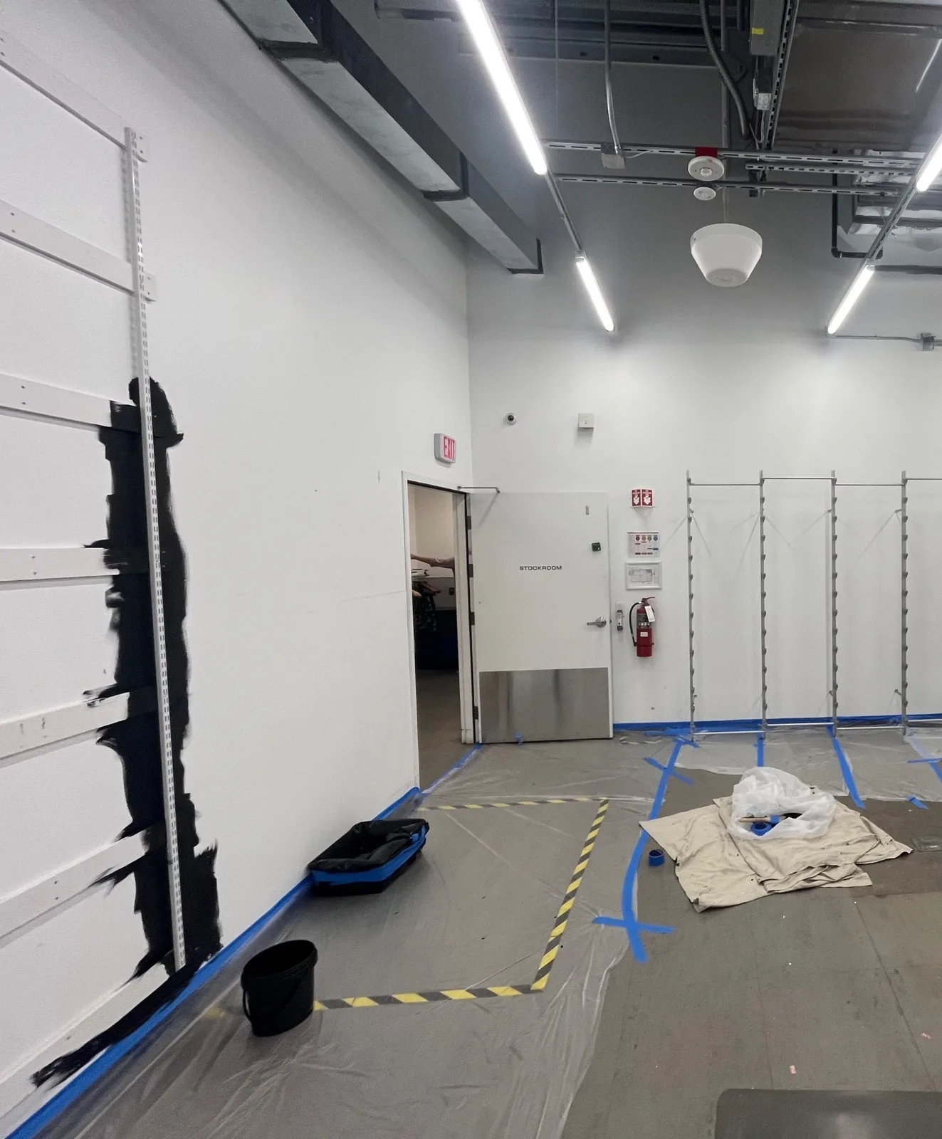 Black shielding coat being cut in along a stockroom wall
